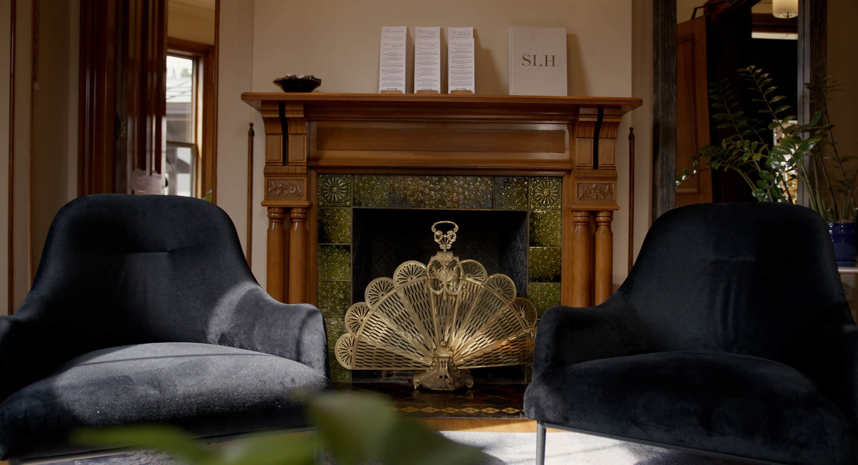 Elegant lounge area with plush chairs and fireplace in Portland Maine luxury hotel.