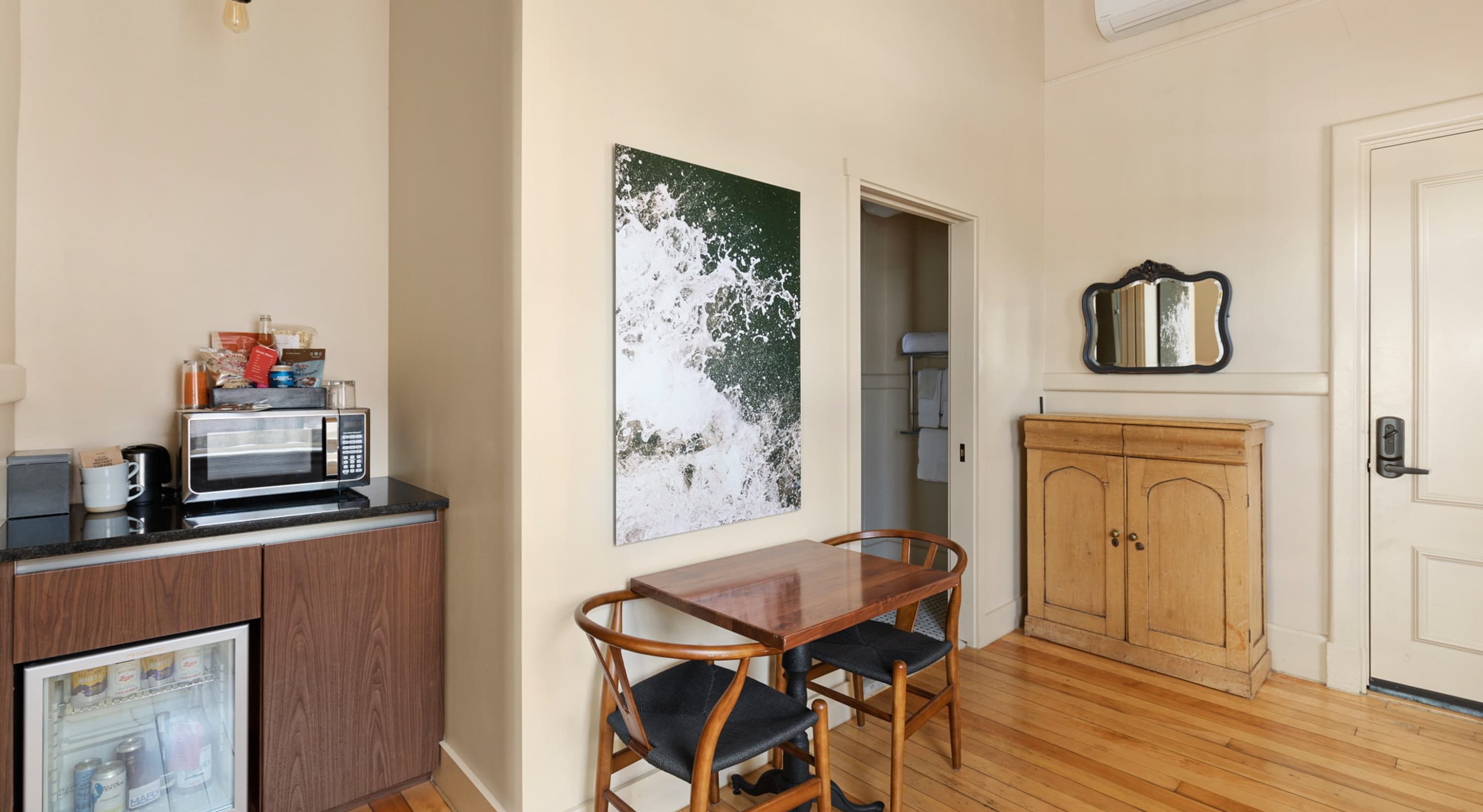 Cozy hotel room with kitchenette and seating area, ideal for Portland Maine getaway.