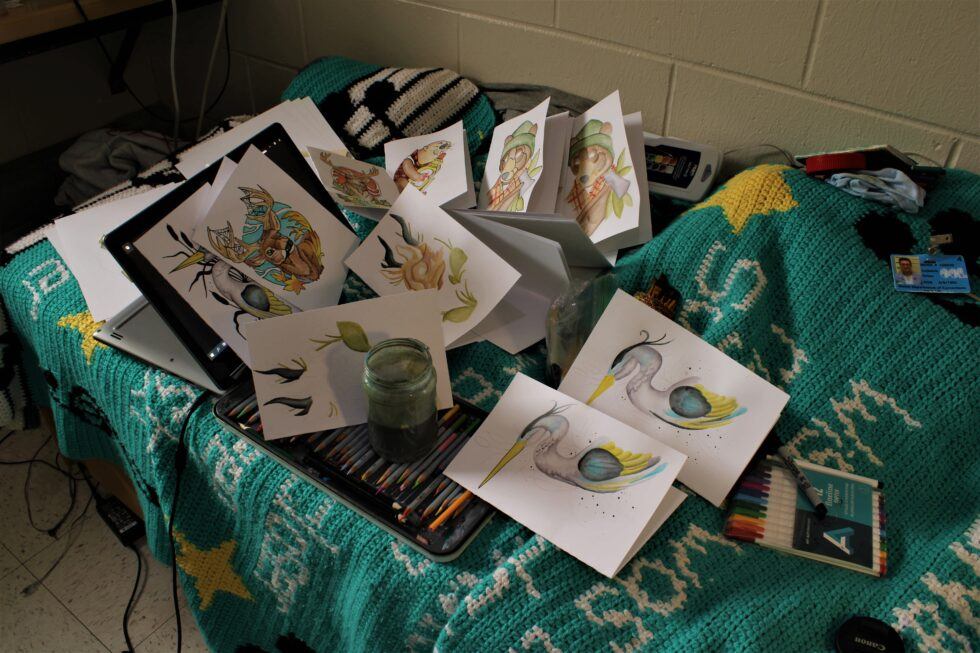 Artistic workspace with colorful drawings and supplies on a cozy blanket