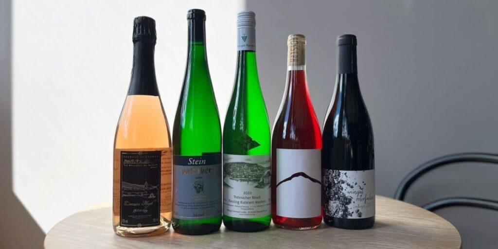 Five assorted wine bottles displayed elegantly on a wooden table in a Portland Maine hotel.