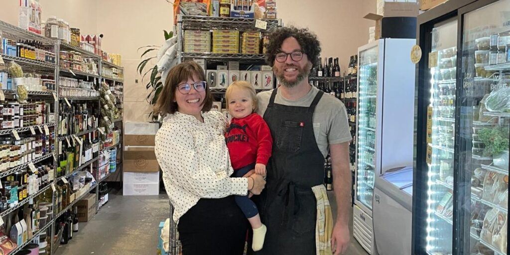 Family in local store, ideal for a Portland Maine getaway, surrounded by shelves of goods.