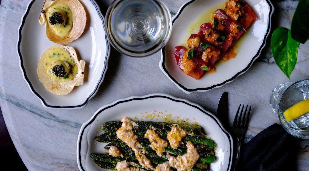 Elegant dishes on a marble table suggest a luxurious boutique escape in Portland, Maine.