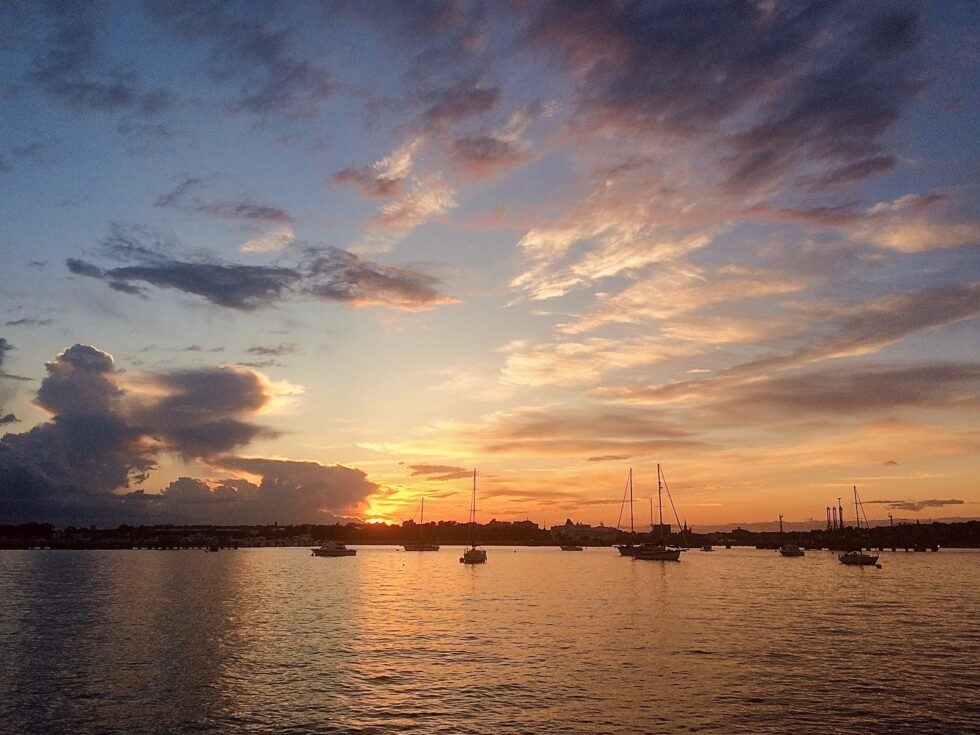 Sunset over a serene harbor in Portland, Maine, perfect for a Portland Maine getaway.